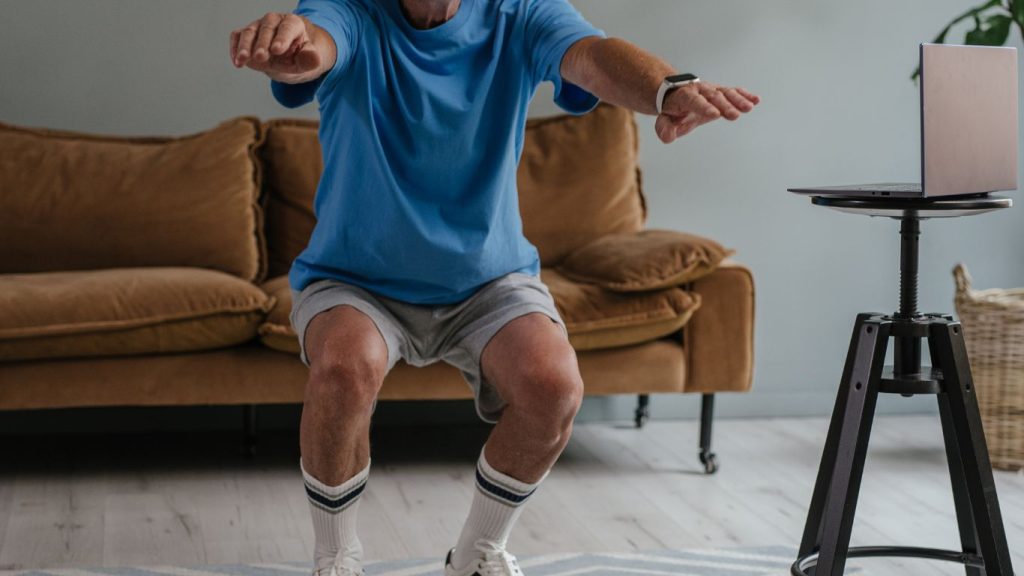 elderly man squats in his living room