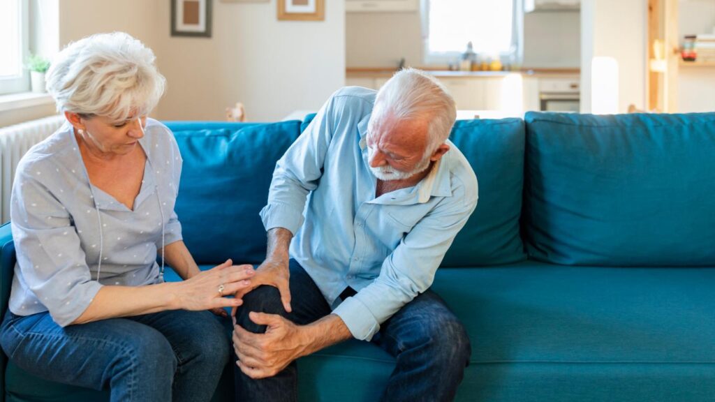 wife helps man who is holding his knee