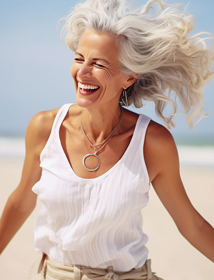 happy woman with white hair running on beach