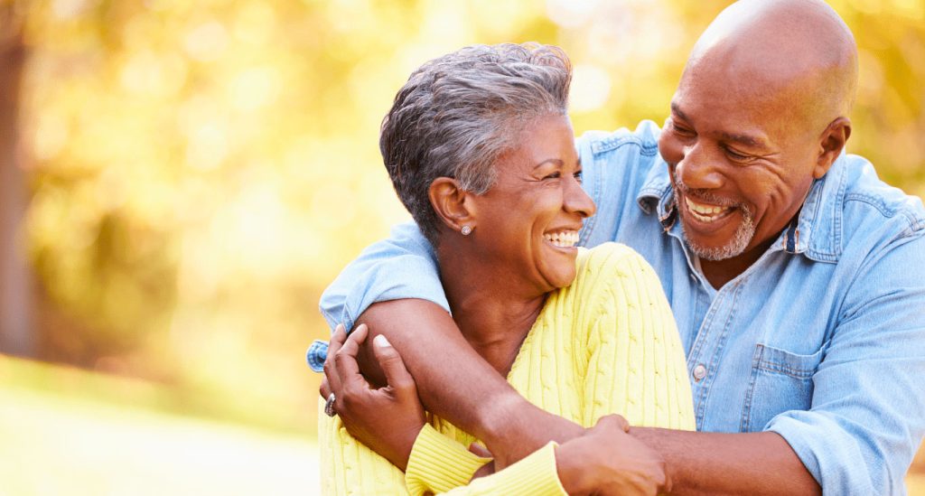 Man wrapping his arms around his wife, smiling
