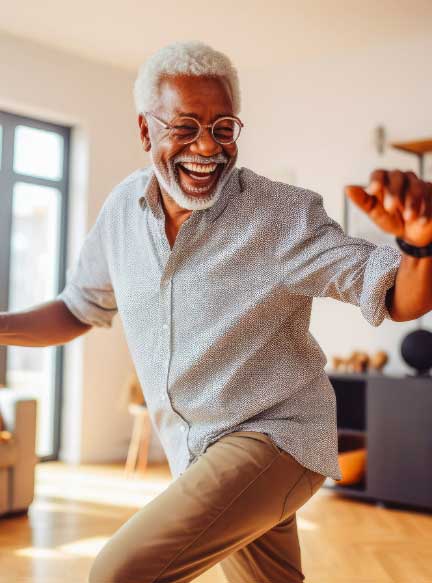 older black man in living room smiling because of knee pain relief
