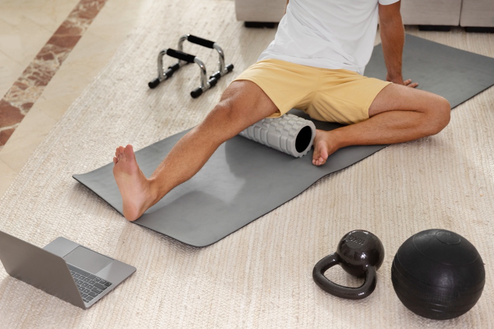 Man using a foam roller at home to improve circulation and reduce knee arthritis pain.