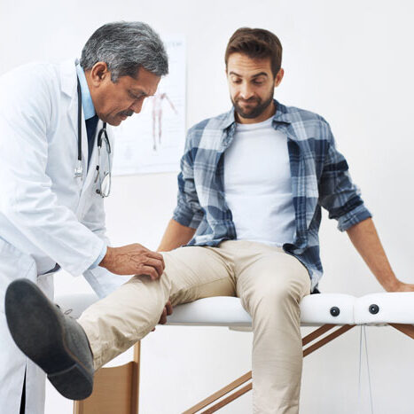 Healthcare,-patient-with-knee-pain-and-doctor-at-clinic